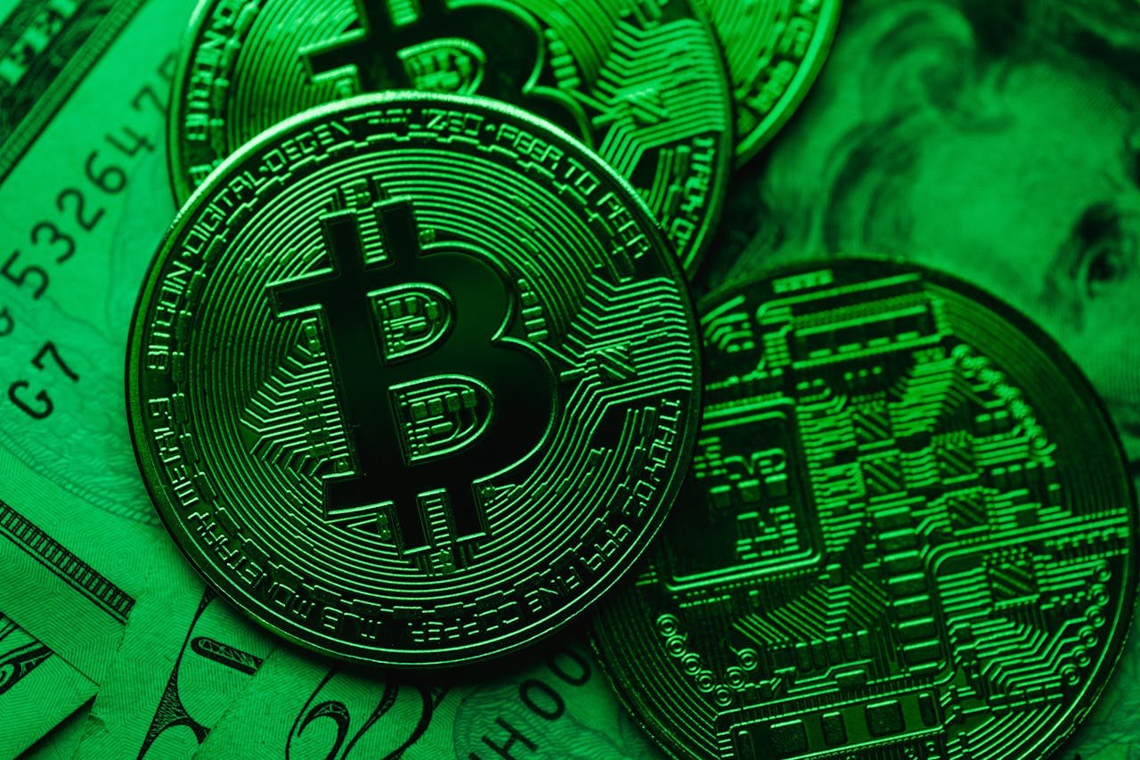 Close-up of Bitcoin coins on paper cash, with a green color tint.